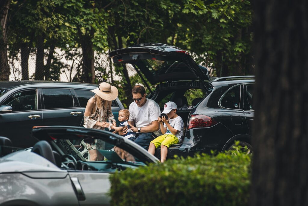 Modern American family with children sitting by their SUV, representing trust, safety, and the protection offered by the best auto insurance companies in the USA.